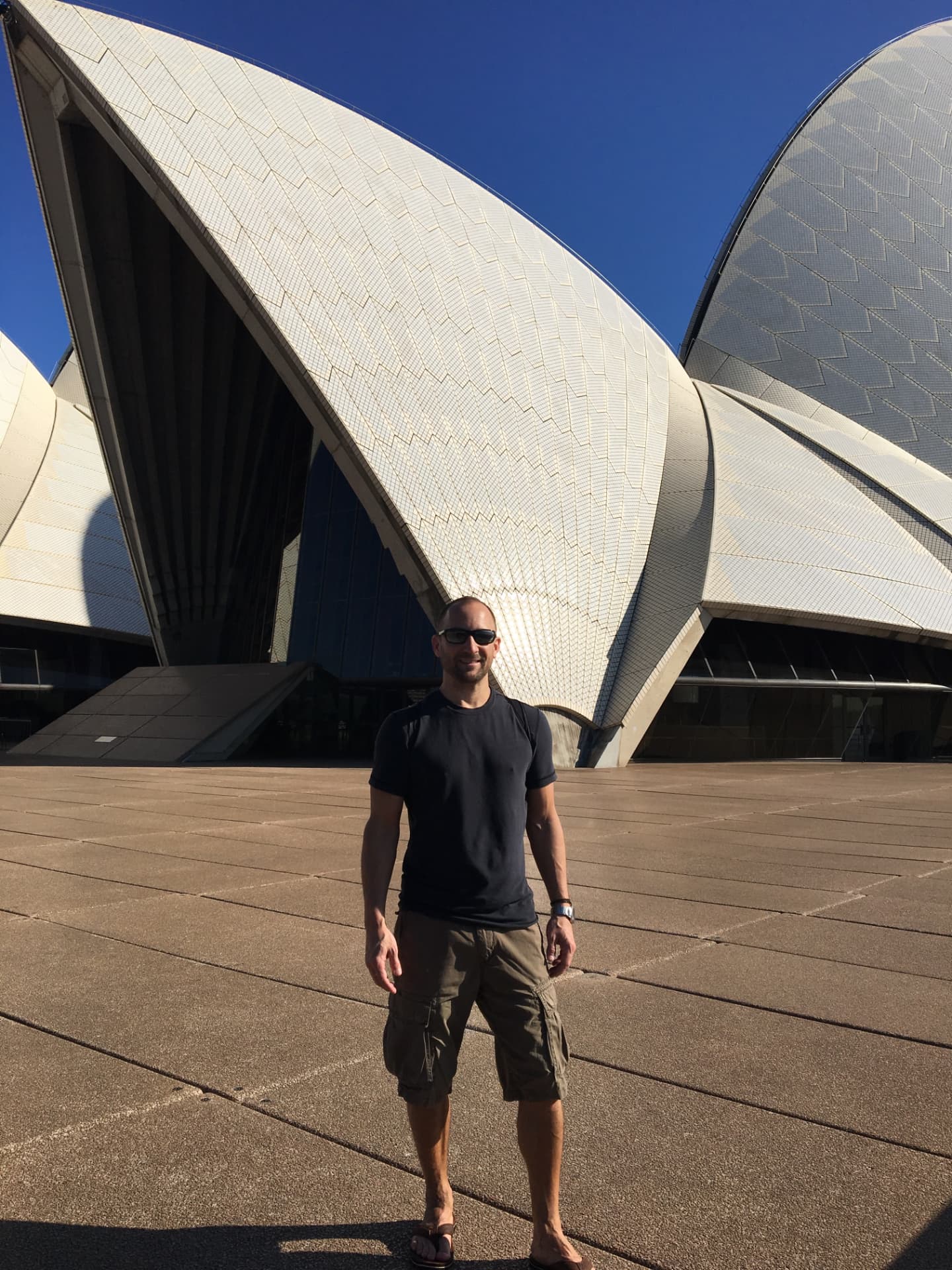 Jason Woods in front of the Sydney Opera House while traveling